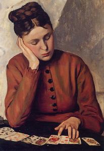 Seated woman studying a card layout